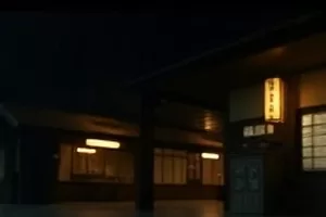 昏暗码头仓库内两名角色相对而立的雨夜场景剧照